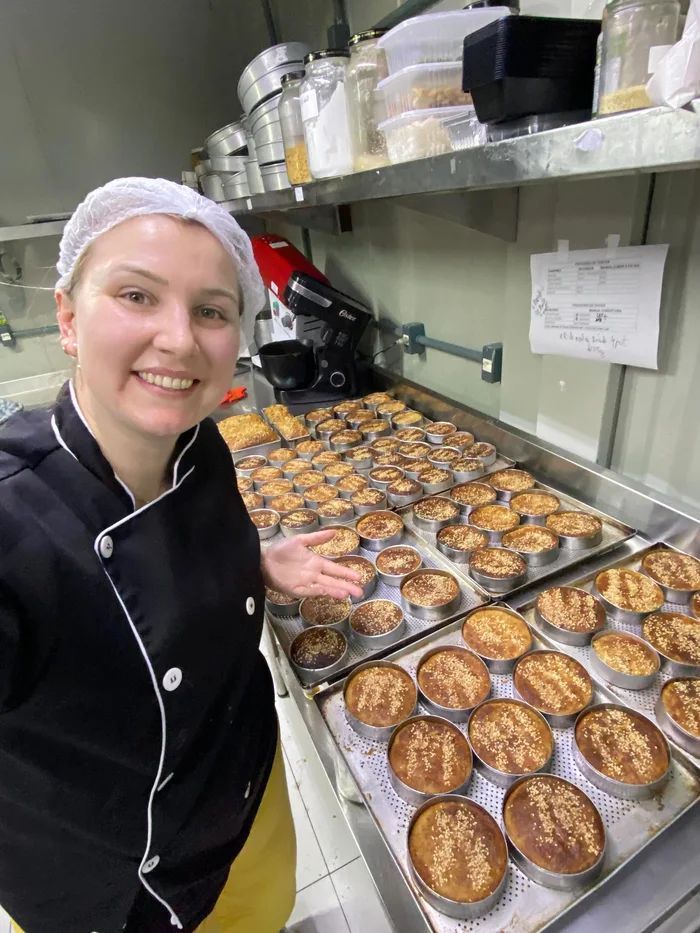 Chef da Sabores do Campo na cozinha de produção com assadeiras de bolinhos